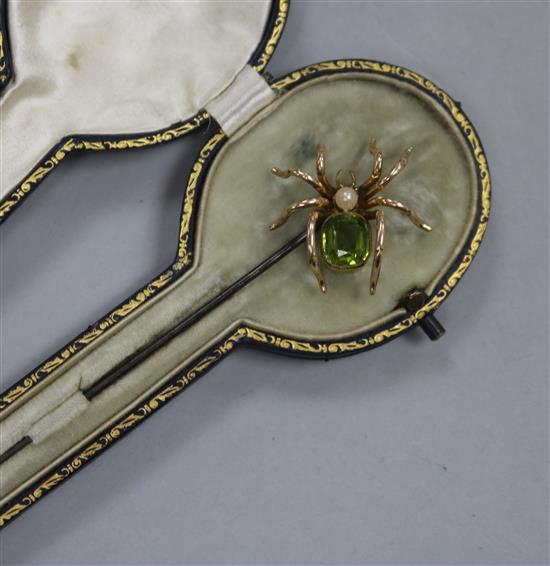 A yellow metal and gem set spider hat pin in original box, 17cm.